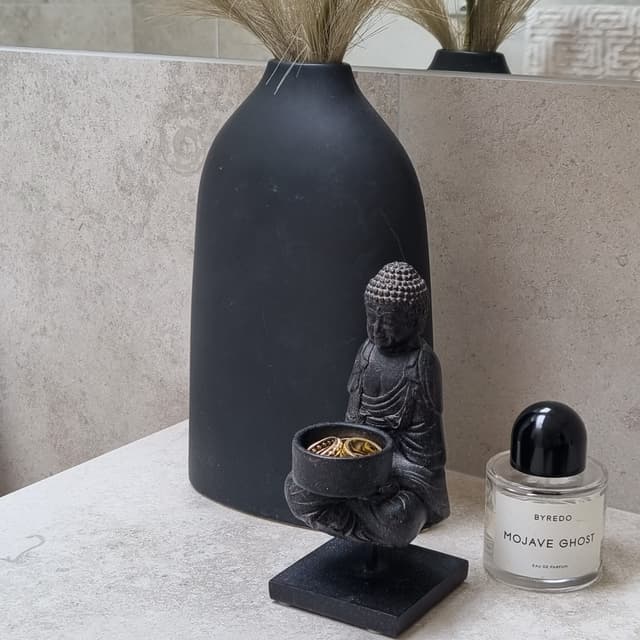 Detaljbild svart vas och buddah