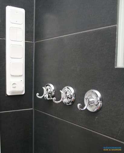 Badrum med belysta nischer i svart mosaik