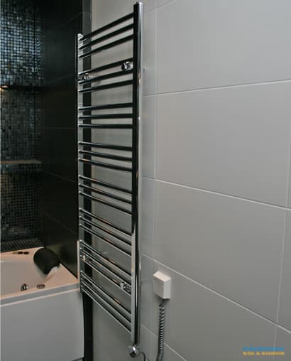 Badrum med belysta nischer i svart mosaik