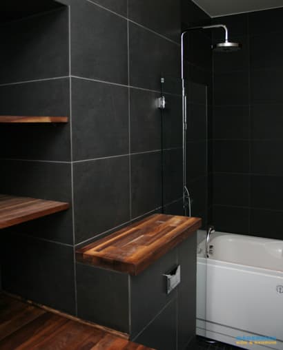 Badrum med belysta nischer i svart mosaik