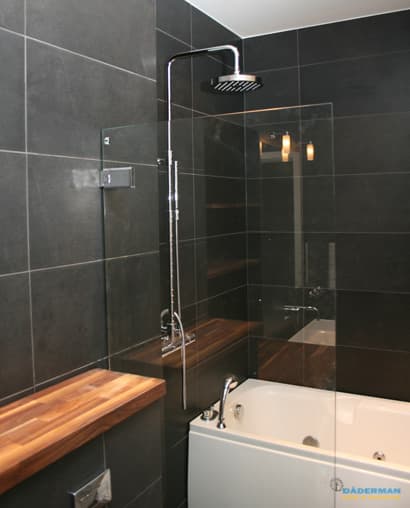 Badrum med belysta nischer i svart mosaik