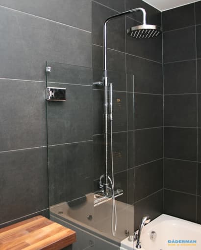 Badrum med belysta nischer i svart mosaik