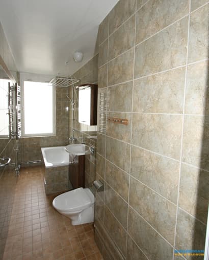 Avlångt badrum med inbyggt badkar