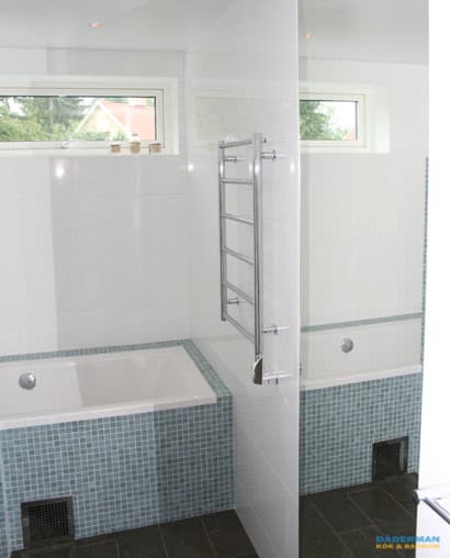 Badrum med blå mosaik och badkar