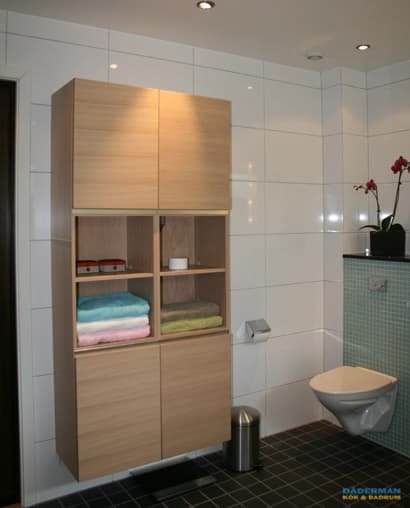 Badrum med blå mosaik och vitt kakel