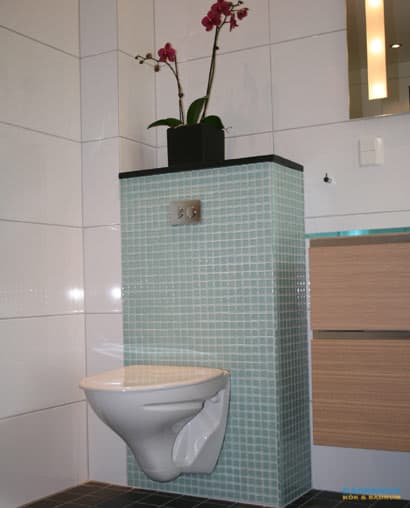 Badrum med blå mosaik och vitt kakel