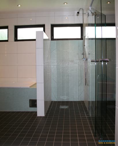 Badrum med blå mosaik och vitt kakel