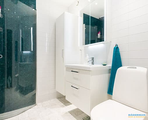 Ljust badrum med mörkblå mosaik