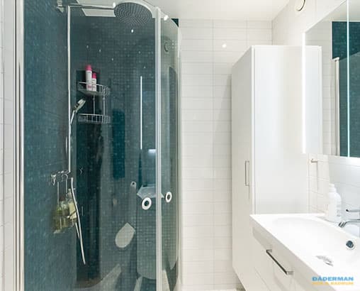 Ljust badrum med mörkblå mosaik