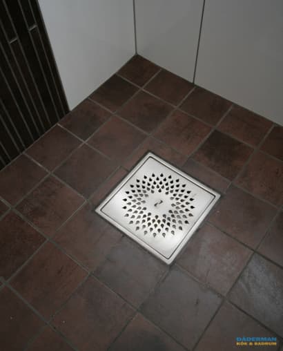 Badrum med golv i brunt klinker