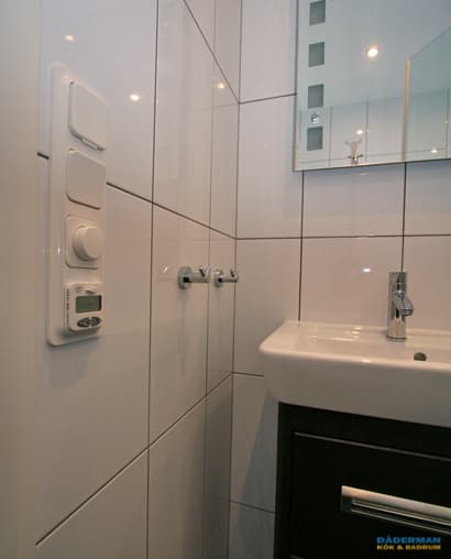 Badrum med golv i brunt klinker