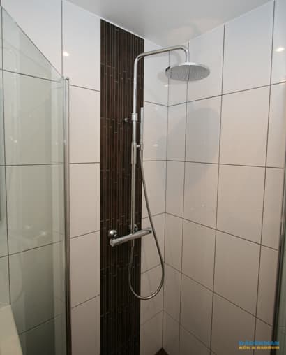 Badrum med golv i brunt klinker