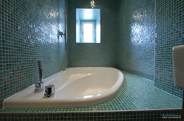 Badrum med inbyggd badplats i blågrön mosaik