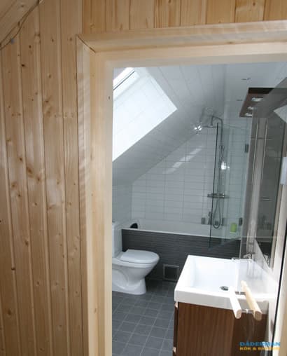 Badrum med inbyggt badkar och bastu