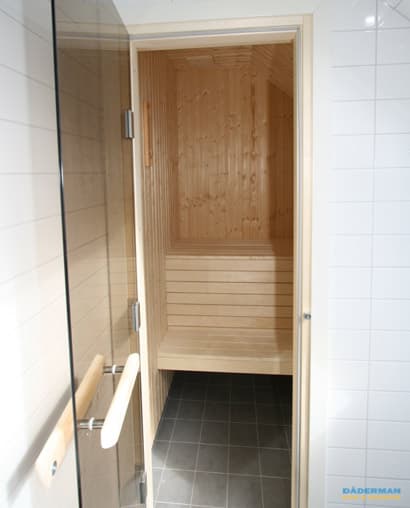 Badrum med inbyggt badkar och bastu