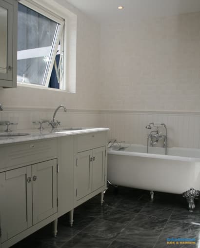 Badrum med marmorgolv och dubbelhandfat