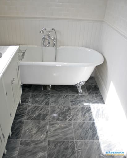 Badrum med marmorgolv och dubbelhandfat