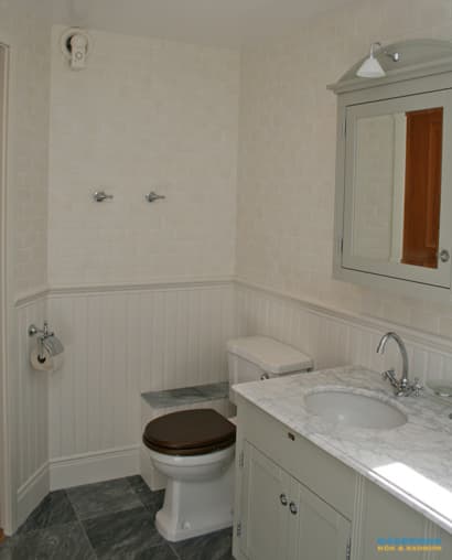 Badrum med marmorgolv och dubbelhandfat