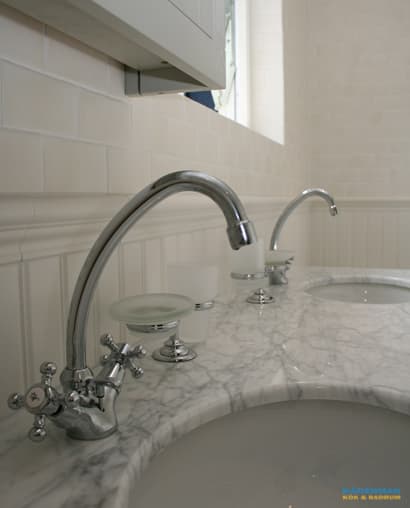 Badrum med marmorgolv och dubbelhandfat