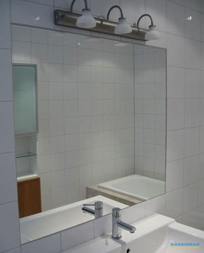 Badrum med vitt kakel och beiget klinker