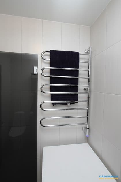 Badrum med vitt kakel och grå klinker