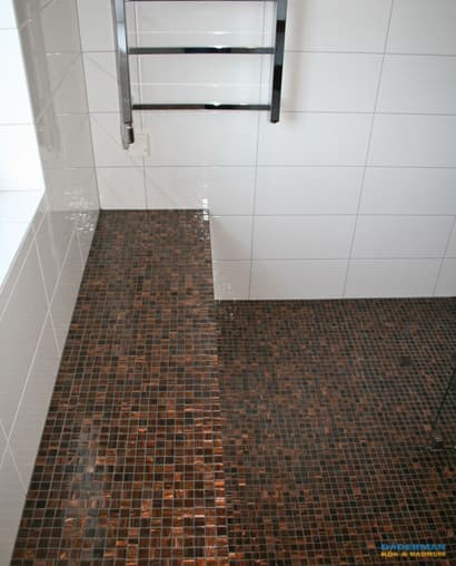 Snyggt badrum med brun mosaik