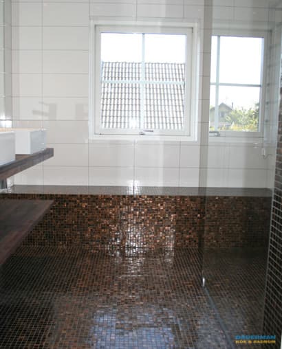 Snyggt badrum med brun mosaik