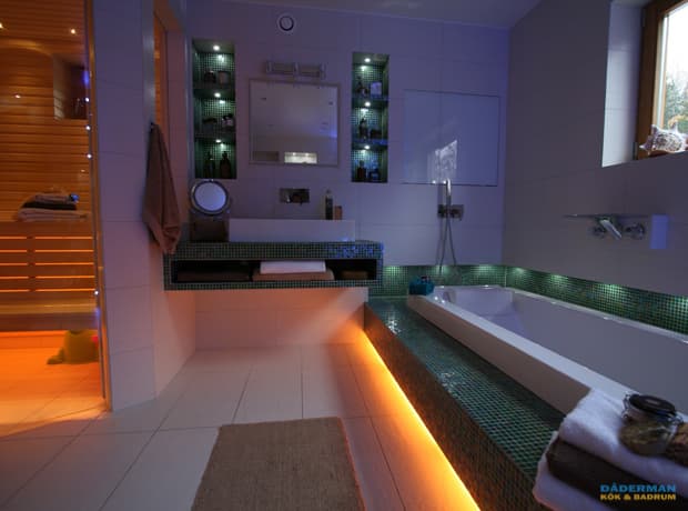 Badrum i exklusiv stil med grön mosaik, inbyggt badkar, väggspegel och bastu