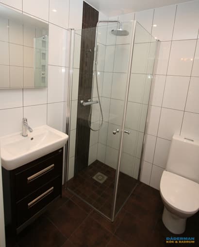 Badrum med golv i brunt klinker