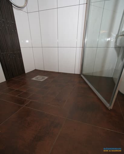 Badrum med golv i brunt klinker