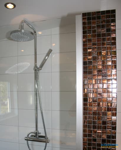 Snyggt badrum med brun mosaik