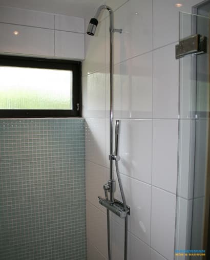 Badrum med blå mosaik och vitt kakel