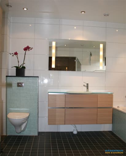 Badrum med blå mosaik och vitt kakel