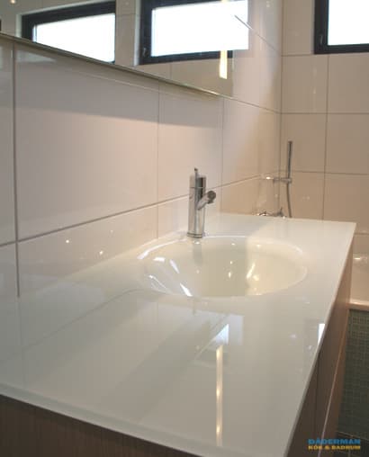 Badrum med blå mosaik och vitt kakel