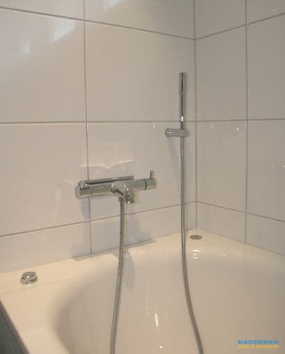 Badrum med blå mosaik och vitt kakel