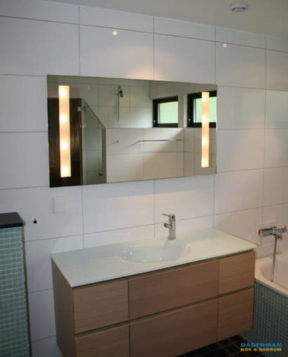 Badrum med blå mosaik och vitt kakel