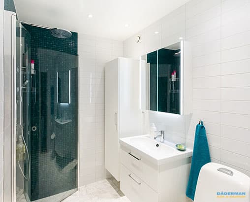 Ljust badrum med mörkblå mosaik