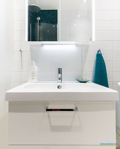 Ljust badrum med mörkblå mosaik